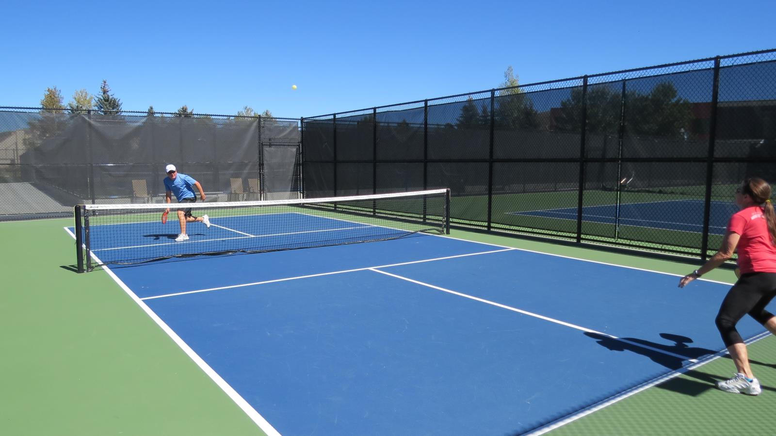 several outdoor courts with green and blue playing surfaces